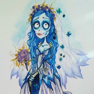 May include: A watercolor illustration of a blue-skinned bride with a white wedding dress, a floral crown, and a bouquet of purple flowers. She has a skeletal appearance and is surrounded by blue butterflies.
