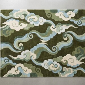 Könnte beinhalten: Ein rechteckiger Teppich mit dunkelolivgrünem Hintergrund und einem sich wiederholenden Muster aus stilisierten, wirbelnden Wolken in Creme-, Hellblau- und Salbeigrüntönen. Das Design besteht aus geschichteten, geschwungenen Formen mit klaren Kanten.