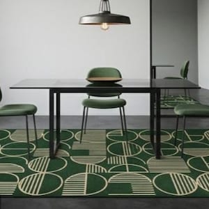 Könnte beinhalten: Ein rechteckiger Teppich mit dunkelgrünem Hintergrund und einem sich wiederholenden geometrischen Muster aus weißen Kreisen und Halbkreisen, die mit feinen horizontalen Linien gefüllt sind. Der Teppich liegt unter einem schwarzen Esstisch.