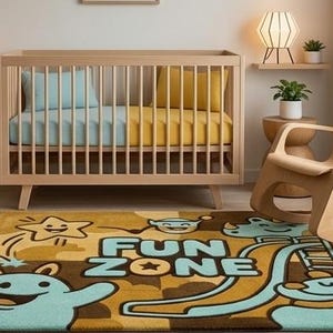 Könnte beinhalten: Ein rechteckiger Teppich mit einem Cartoon-Design und dem Schriftzug "FUN ZONE" in hellblauen Buchstaben. Der Teppich zeigt hellblaue Monsterfiguren, einen gelben Stern und eine Rutschengrafik auf einem braun-gelb gemusterten Hintergrund.