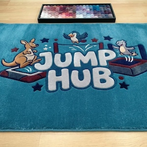 Könnte beinhalten: Ein rechteckiger, blaugrüner Teppich mit dem Schriftzug JUMP HUB in großen, hellgrauen Buchstaben. Das Design zeigt ein Känguru, einen Vogel und ein kleines Wesen, die auf Trampolinen springen, akzentuiert durch dunkelblaue Sterne und rote Details.