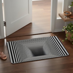 Può includere: Uno zerbino rettangolare caratterizzato da un motivo a illusione ottica in bianco e nero che crea l'effetto visivo di un tunnel o buco quadrato profondo e rientrante al centro. Il design è composto da linee concentriche che convergono verso il centro.