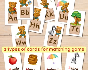 May include: Educational flashcards featuring cartoon bears with letters and objects. The cards display the alphabet, with corresponding images like an apple, umbrella, and zebra. The text "2 types of cards for matching game" is also visible.