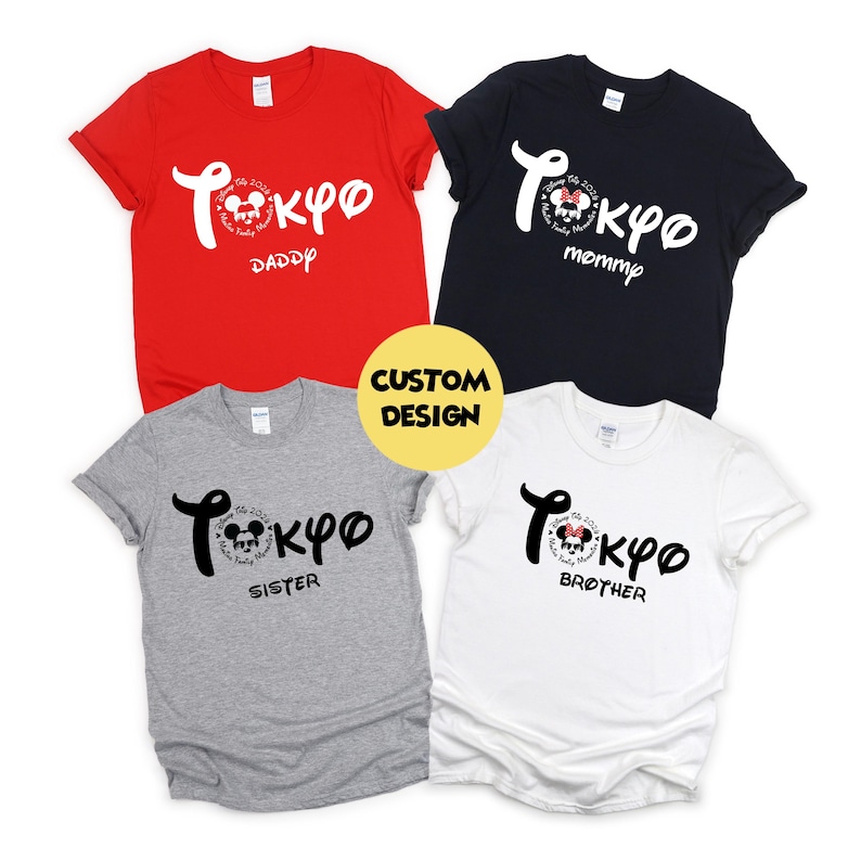 May include: Four short-sleeved t-shirts in red, black, gray, and white. Each shirt has a unique design with the word "Tokyo" in a stylized font, along with the words "Daddy," "Mommy," "Sister," and "Brother."