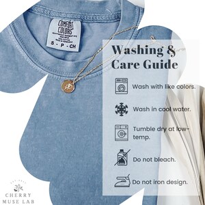 May include: A light blue t-shirt with a Comfort Colors tag, a gold necklace, and a "Washing & Care Guide" graphic. The guide includes washing instructions: wash with like colors, wash in cool water, tumble dry at low-temp, do not bleach, and do not iron design.