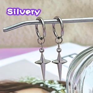 May include: A pair of silver-colored hoop earrings with star-shaped pendants. The earrings are hanging from a silver bar. The word "Silvery" is written in a purple font at the top of the image.
