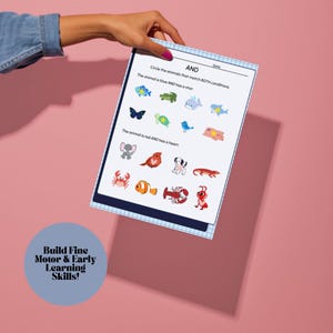 K&ouml;nnte beinhalten: Ein Arbeitsblatt f&uuml;r Kinder mit Tierillustrationen und dem Wort "UND". Die Anweisungen fordern auf, Tiere zu umkreisen, die den Bedingungen entsprechen. Das Arbeitsblatt wird von einer Hand vor einem rosa Hintergrund gehalten. Der Text "Feinmotorik & fr&uuml;he Lernf&auml;higkeiten aufbauen!" ist ebenfalls sichtbar.