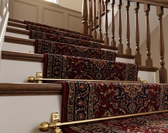 May include: A staircase featuring a dark red patterned runner rug secured by polished brass stair rods with spherical finials. The wooden steps have white risers and a dark wood handrail with vertical balusters extending up the staircase.