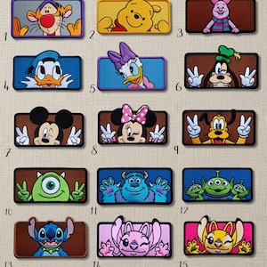 Puede incluir: Una colección de parches bordados rectangulares con varios personajes de dibujos animados. Los parches incluyen personajes como Tigger, Winnie the Pooh, Piglet, Donald Duck, Daisy Duck, Goofy, Mickey Mouse, Minnie Mouse, y otros. Cada parche tiene un diseño y esquema de color únicos.