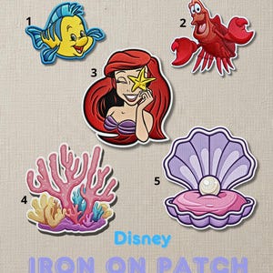 May include: Embroidered iron-on patches featuring characters from Disney's The Little Mermaid. Includes Flounder, Sebastian, Ariel, coral, and a pearl in an open shell. The text "Disney IRON ON PATCH" is also present.
