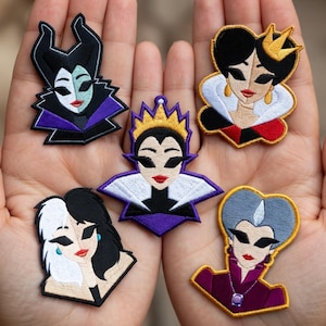 May include: A collection of embroidered patches depicting Disney villains. The patches feature characters such as Maleficent, the Evil Queen, and Cruella de Vil. They are brightly coloured and intricately stitched, suitable for application on clothing or accessories.