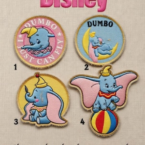 以下が含まれることがあります： 様々なポーズのダンボが描かれた、刺繍されたディズニーのパッチ。パッチは円形で、ライトブルーの背景にピンク、黄色、赤のアクセントがあります。「Disney」の文字がピンクの筆記体で上部にあります。「Just Can Fly」の文字が1つのパッチにあります。