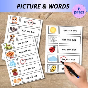 May include: Educational flashcards with the text "PICTURE & WORDS" and "15 pages". The cards feature colorful illustrations and word association exercises. A hand is holding a pen, circling a word on one of the cards.