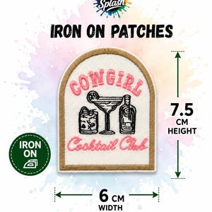 May include: An arched iron-on patch with a white background and a tan border. It features pink embroidered text reading COWGIRL Cocktail Club, with black embroidered illustrations of a martini glass, a glass of whiskey, and a bottle. It measures 7.5 cm in height and 6 cm in width.