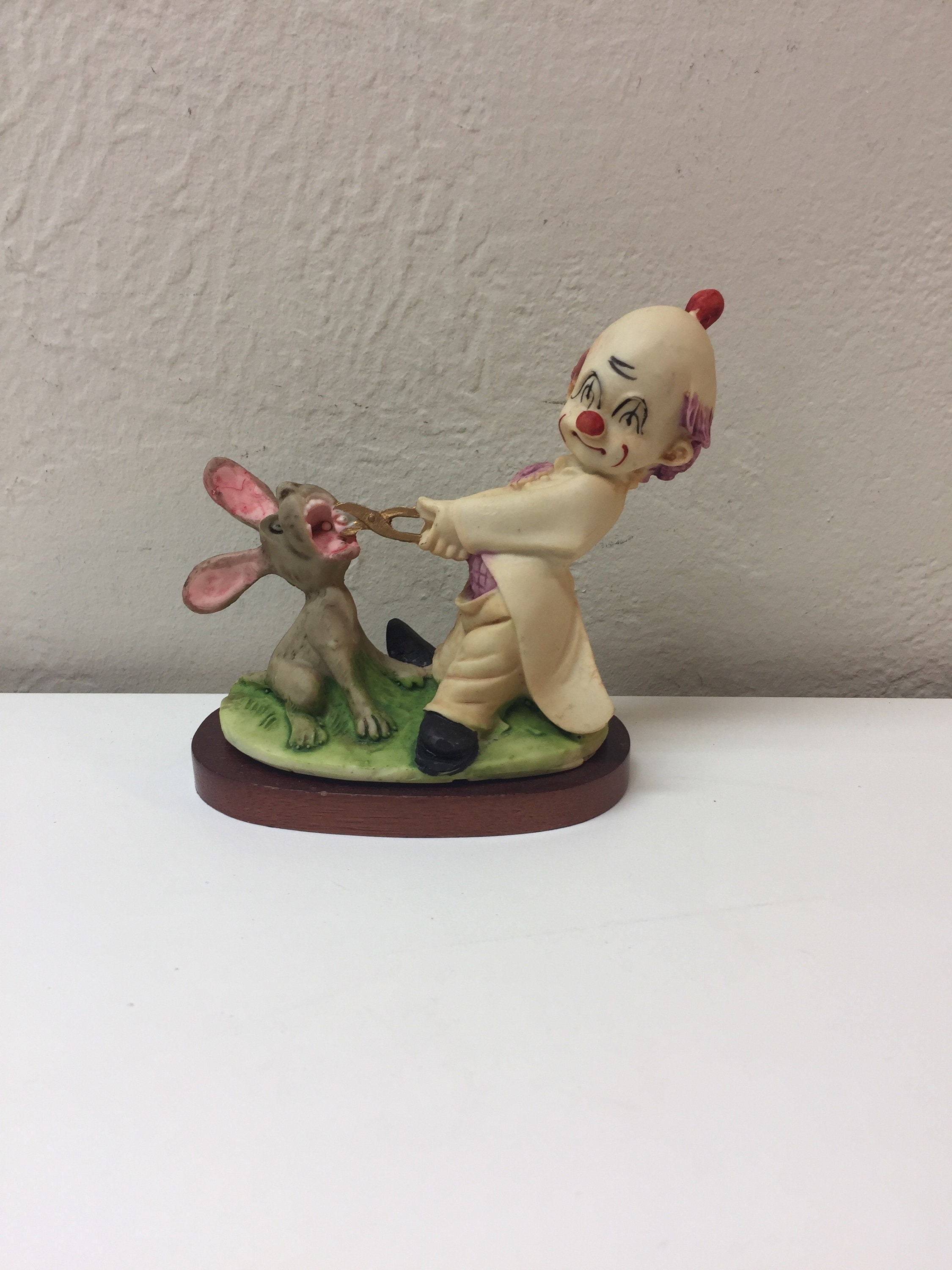 Vintage Figur eines Clowns, der den Zahn eines Esels mit Zange zieht.
