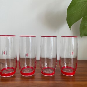 Peut inclure: Ensemble de quatre verres à boire en verre transparent avec un bord rouge et un logo rouge qui dit "G.B. & Co."