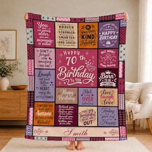 May include: A rectangular throw blanket featuring a patchwork design with various shades of pink, purple, orange, and cream. The blanket displays inspirational birthday quotes and the text Happy 70th Birthday To You and the name Smith.