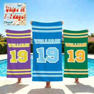 May include: Three rectangular beach towels in purple, blue, and green. Each towel features the name WILLIAM in white block letters above the number 19 in a contrasting color, framed by horizontal stripes at the top and bottom edges.