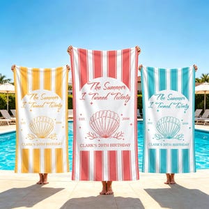 May include: Three beach towels with vertical stripes in yellow, coral, and teal. Each towel features the text "The Summer I Turned Twenty" and "Clark's 20th Birthday" with a seashell graphic. The towels are held up in front of a pool.