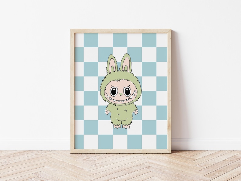 May include: A framed print featuring a cartoon character in a green bunny costume with a menacing grin. The background is a blue and white checkered pattern. The artwork is displayed in a light-colored wooden frame.