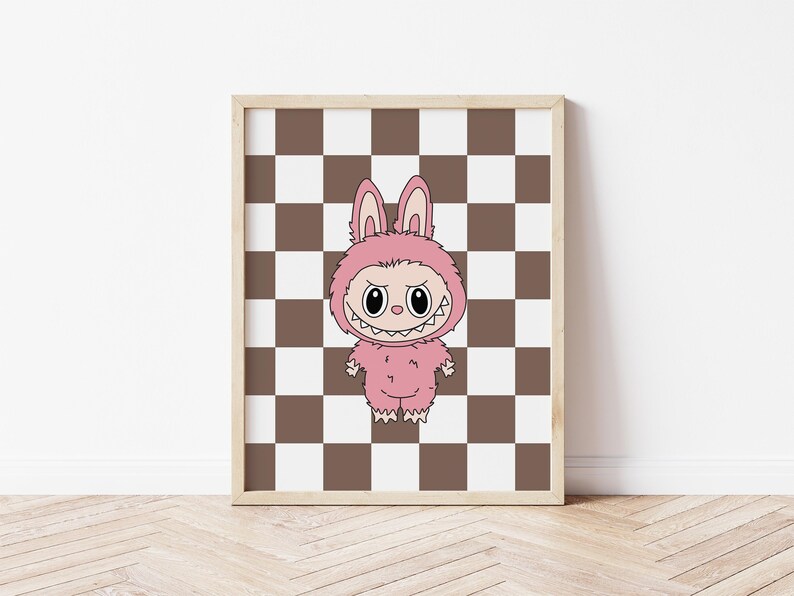 May include: A framed print featuring a cartoon character in a pink bunny costume with a menacing expression. The artwork is set against a brown and white checkered background, framed in a light wood.