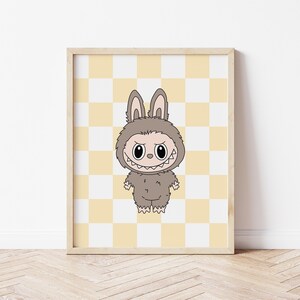 May include: Framed print featuring a cartoon character in a furry bunny costume with a menacing grin. The character is brown with large eyes and a toothy smile. The background is a yellow and white checkered pattern.