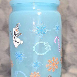 May include: A light blue tumbler with a matching lid and straw. The tumbler is decorated with images of Olaf the snowman, snowflakes, and a candy cane. A fun, reusable drinking cup.