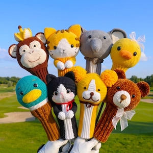 Pode incluir: Uma coleção de oito capas de crochê para tacos de golfe com vários designs de animais, incluindo um macaco com coroa, um tigre, um elefante, um pato amarelo, um pato-real, um gato preto e branco, um cão e um urso castanho com laço branco.