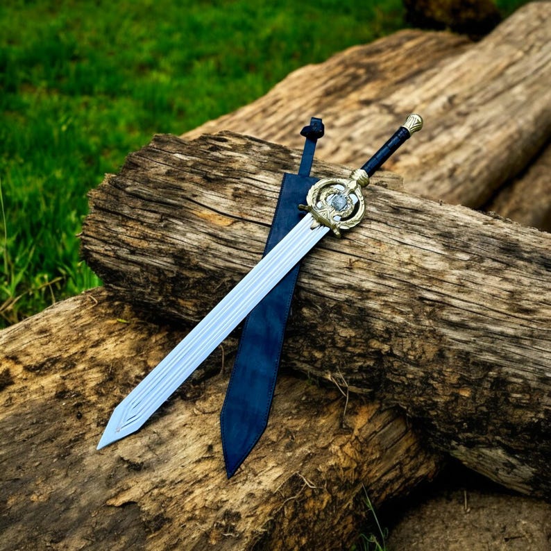 May include: A decorative sword with a silver blade and ornate gold hilt rests on a weathered wooden log. The sword's handle is black, and it is paired with a dark blue sheath. The background features green grass.