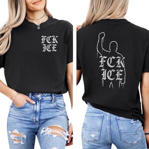 Puede incluir: Camiseta negra con el texto "FCK ICE" en fuente g&oacute;tica en la parte delantera. La parte trasera de la camiseta presenta la silueta de una persona con el pu&ntilde;o en alto y el mismo texto. La camiseta se lleva con vaqueros azules.