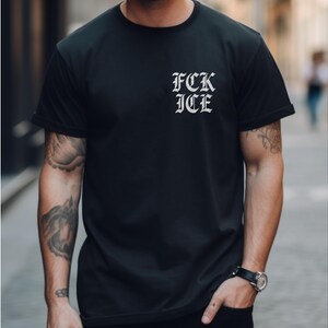 Puede incluir: Camiseta negra con el texto "FCK ICE" en fuente g&oacute;tica en la parte superior izquierda del pecho. La camiseta es de manga corta y parece estar hecha de un material suave.