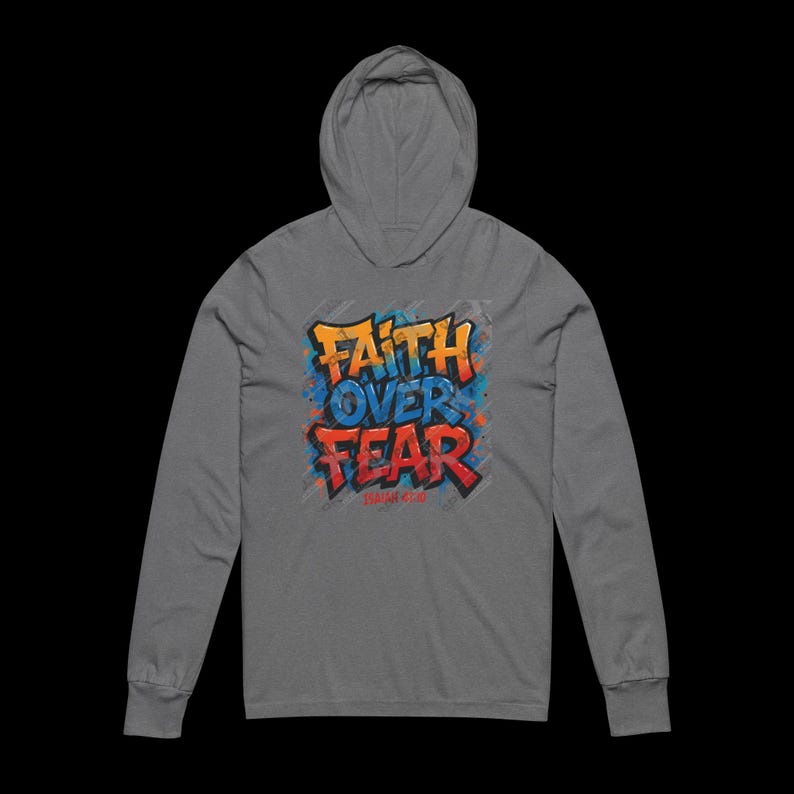 Peut inclure: Un sweat &agrave; capuche gris &agrave; manches longues. Le devant affiche les mots "FAITH OVER FEAR" dans un style graffiti. Le texte est en orange et rouge avec des accents bleus. Le sweat &agrave; capuche a une capuche et une coupe d&eacute;contract&eacute;e.