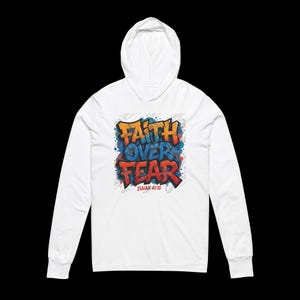 Peut inclure: Un sweat &agrave; capuche blanc &agrave; manches longues avec l'inscription "Faith Over Fear" en style graffiti. Le texte est en orange, bleu et rouge, avec le verset biblique Isa&iuml;e 41:10 en dessous. Le sweat a une capuche et des manches longues.
