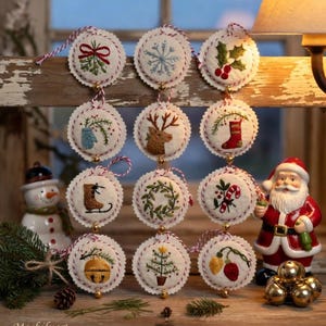 May include: A collection of twelve embroidered Christmas ornaments with various festive designs, including a snowflake, holly, and a Christmas tree. Each ornament is round, white, and trimmed with red and white thread. A Santa Claus figurine and snowman are in the background.
