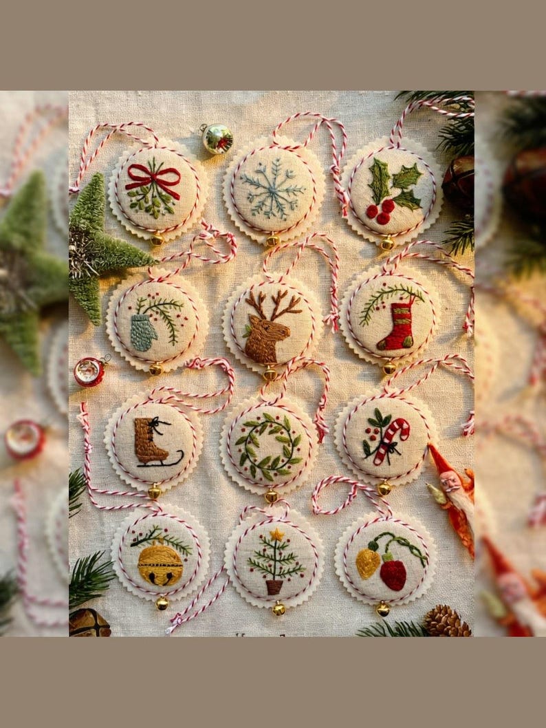May include: A collection of embroidered Christmas ornaments with various festive designs, including a snowflake, holly, and a reindeer. Each ornament is round, with a scalloped edge and a red and white string for hanging. Small gold bells are attached.