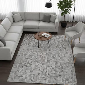 May include: A modern living room setup featuring a light gray sectional sofa, two armchairs, and a round coffee table. A geometric patterned rug in shades of gray and white covers the floor. A black floor lamp and a potted plant add to the decor.