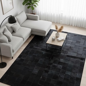 May include: A contemporary living room with a black geometric patterned rug. A light grey sectional sofa, a wooden coffee table, and a floor lamp are also visible. The room is well-lit with natural light from a large window.