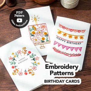 Op de afbeelding: Drie witte verjaardagskaarten met kleurrijke borduurontwerpen. Eén kaart heeft een taart, een andere slingers en de derde een bloemenkrans. De kaarten zijn voorzien van de tekst "Happy Birthday". De afbeelding bevat ook een PDF-patroon met video-instructies.