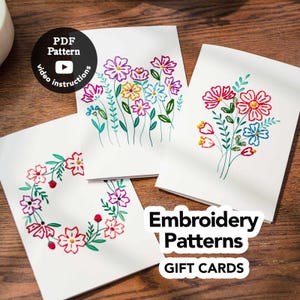 May include: Three white cards featuring colourful floral embroidery patterns. One card displays a circular wreath, while the others show vertical flower arrangements. A black circular badge reads PDF Pattern video instructions, and text reads Embroidery Patterns GIFT CARDS.