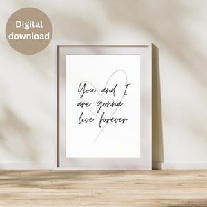 May include: A framed print with the text "You and I are gonna live forever" in black script, with a gray heart outline. The print is in a white frame and is labeled "Digital download" in a tan circle.
