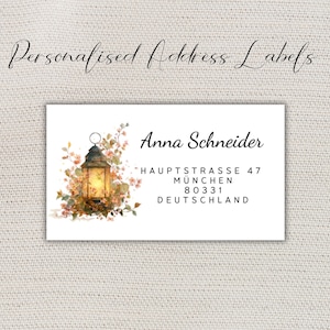 Pode incluir: Etiqueta de endereço branca com o texto "Personalised Address Labels" em escrita cursiva. A etiqueta apresenta uma ilustração em aquarela de uma lanterna com detalhes florais. O nome e o endereço do destinatário são impressos em preto.