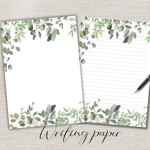 Può includere: Due fogli di carta da scrivere bianca con un design ad acquerello di eucalipto. Un foglio è vuoto, l'altro ha linee orizzontali. Una penna nera è appoggiata sulla carta a righe. Le parole "Writing paper" sono scritte in corsivo in basso.