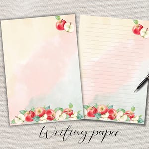 Può includere: Due fogli di carta da scrivere con un design ad acquerello. La carta ha uno sfondo rosa e giallo chiaro ad acquerello. Mele rosse e foglie verdi decorano il bordo inferiore e l'angolo in alto a destra. Una penna nera poggia sul foglio a righe. Le parole "Writing paper" sono in basso.