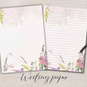 Può includere: Due fogli di carta da scrivere bianchi con disegni floreali ad acquerello. Un foglio è vuoto, l'altro ha pagine a righe. Il motivo floreale comprende fiori rosa, gialli e viola con fogliame verde. Il testo "Writing paper" è scritto in corsivo.