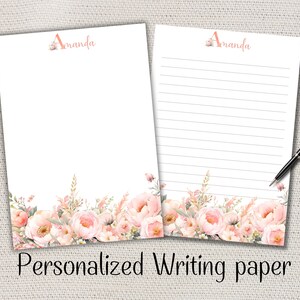 Peut inclure: Deux feuilles de papier à lettres personnalisées avec un motif floral. Le haut de chaque feuille porte le nom "Amanda" dans une couleur corail clair. Le bas du papier présente une bordure de fleurs roses et pêche. Le texte "Personalized Writing paper" est en bas.