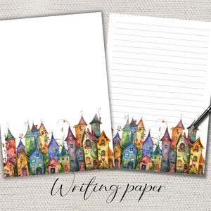 Könnte beinhalten: Zwei Blätter weißes Schreibpapier mit einer farbenfrohen Aquarellillustration von skurrilen Häusern am unteren Rand. Ein Blatt ist leer, das andere hat horizontale Linien. Ein schwarzer Stift liegt auf dem linierten Blatt. Die Worte "Writing paper" sind kursiv geschrieben.