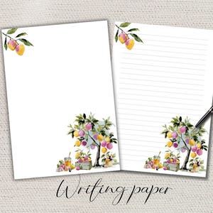 Può includere: Due fogli di carta da scrivere bianchi con un disegno ad acquerello di un albero da frutto con frutti gialli e rosa. Le parole "Writing paper" sono scritte in corsivo. Una penna nera poggia sul foglio a righe.
