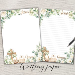Könnte beinhalten: Zwei Blätter weißes Schreibpapier mit floralen und religiösen Designs. Auf der Oberseite jedes Blattes steht in goldener Schrift "Jesus". Der untere Teil zeigt ein Kreuz, Kerzen und das Wort "Amen". Die Worte "Writing paper" stehen unten.