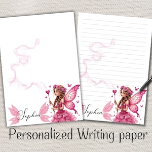 Peut inclure: Deux feuilles de papier à lettres personnalisées avec un motif de fée. La fée porte une robe rose et a des ailes roses. Le nom "Sophia" est écrit sur le papier. Les mots "Personalized Writing paper" sont en bas.