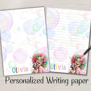 Peut inclure: Deux feuilles de papier à lettres personnalisées avec un motif de bulles. Une feuille est lignée, l'autre est vierge. Les deux présentent une illustration colorée d'une fille avec un chien dalmatien et le nom "Olivia". Le texte "Personalized Writing paper" est en bas.